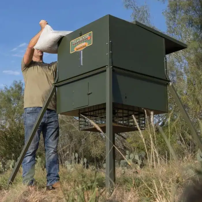 man filling up deer feeder